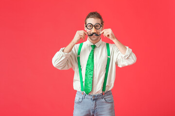 Fototapeta premium Young man in funny disguise on color background. April Fools Day celebration
