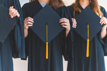 Close up group of graduates holding a hat At the graduation ceremony at the university