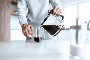 man pours himself a cup of coffee