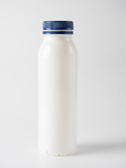 closed plastic milk bottle with blue lid isolated on a white background. Label space, copy space, front view. Plastic recycling