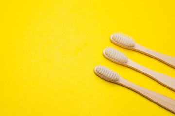 Bamboo brush on a yellow background. No plastic. Ecology. Taking care of the world around you. Toothbrush. Clean teeth. Yellow background. Copy space. of the environment.