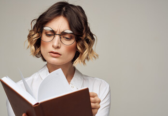 Literate woman with book in hands and in glasses white shirt education model