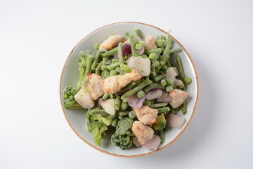 Frozen vegetable mixture of carrots, broccoli ,peppers, red onion and peas with pieces of cut chicken fillet. Healthy food