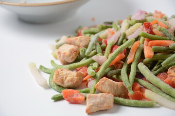 Frozen vegetable mixture of carrots, broccoli ,peppers, red onion and peas with pieces of cut chicken fillet. Healthy food