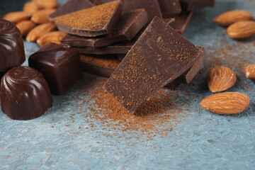 Powder and pieces of tasty chocolate. Coffee beans, cup and almonds.