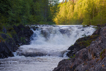 The upper threshold of the Kivach waterfall on a sunny June evening. Karelia, Russia
