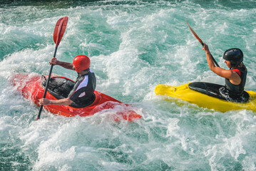 Kajakfahrer spielen mit den Kräften der Natur im Wildwasser der Soca