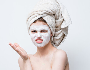 happy woman with white mask on her face naked shoulders clean skin towel on head