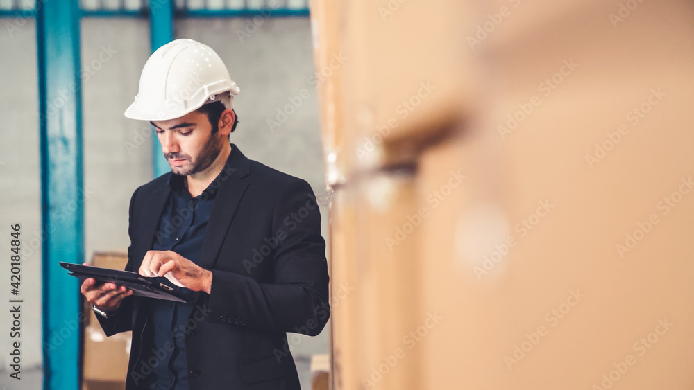 Poster factory manager using tablet computer in warehouse or factory . industry and supply chain management
