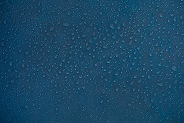 Rain drops texture. Wet raindrops water on glass background. Blue bubble pattern wallpaper.