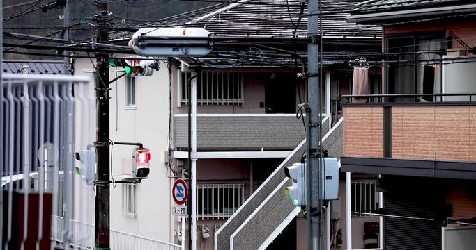 雨の日の住宅街の小さな交差点の信号機とアパート