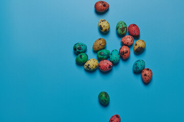 colored painted eggs scattered on a blue background for easter