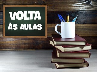 Text in portuguese: "Back to school". "Volta às aulas" written on a green blackboard. 
