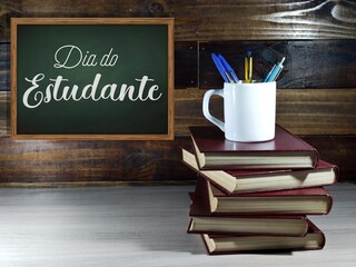 Text dia do estudante, students day in portuguese, against a green chalkboard.