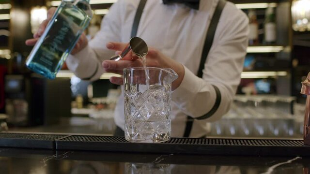 bartender mixing alcoholic cocktail in bar