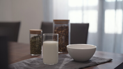 serving chocolate granola pour in white bowl on walnut table