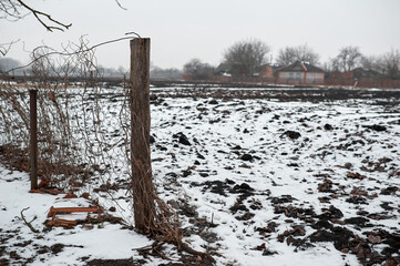 old abandoned village covered with snow near a field, cis early march