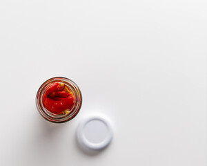 canned chili peppers in a jar on a white background, place for text