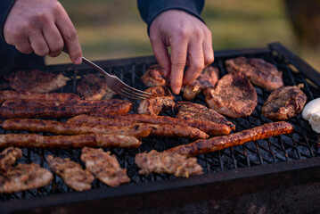 grilled meat cooked and smoked. hands turning the steak on the grill