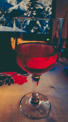 a glass of red wine served in front of the desk
