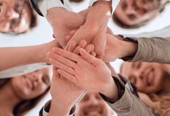 group of young business men clasping their hands together