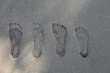 four footprints of friends on the sand