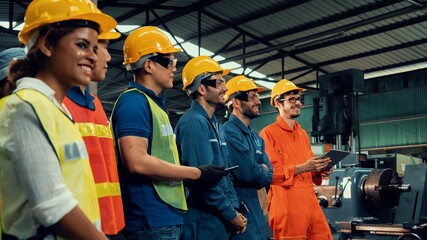 Skillful worker attending brief meeting in the factory . Industrial people and manufacturing labor...