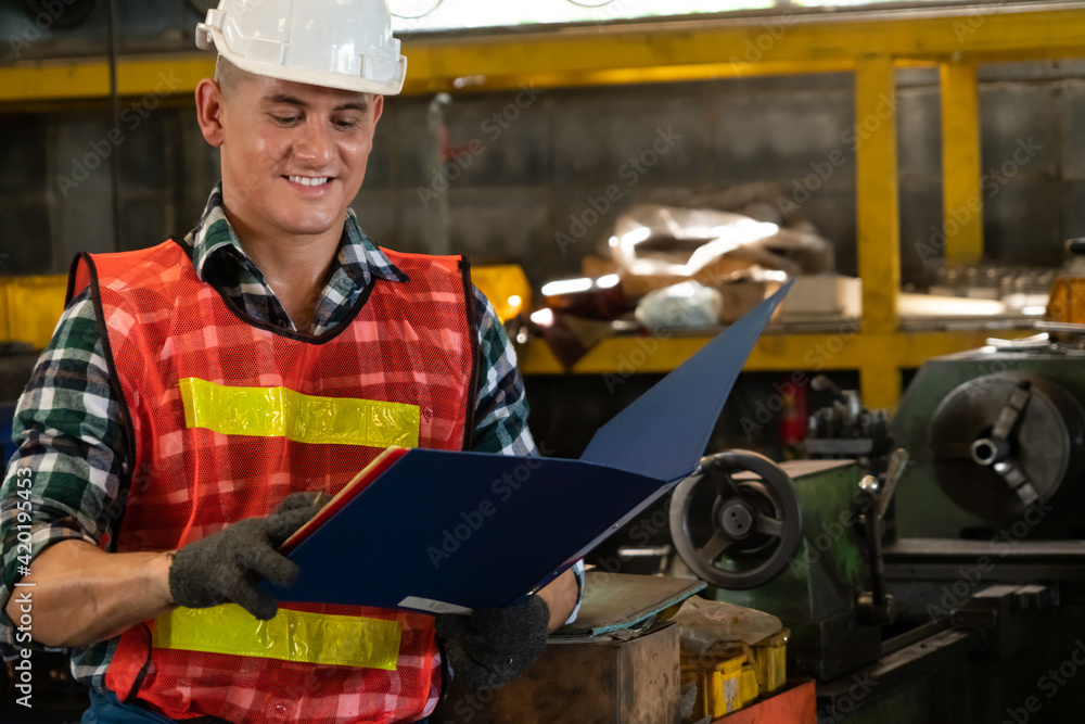 Poster manufacturing worker working with clipboard to do job procedure checklist . factory production line 