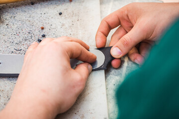 Fototapeta premium Master of leather make holes in the blanks for the belt