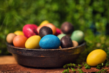 Fototapeta na wymiar Chocolate Easter eggs with egg candies on a wooden table in the yard