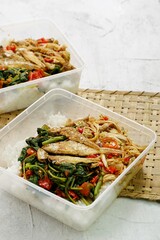 Nasi Gonde Sisit Ayam or known as Nasi Campur Bali, a Balinese Mix Rice made with seasoned green vegetables, shredded chicken, fried salted fish and spicy fresh chili sauce. Selective focus  