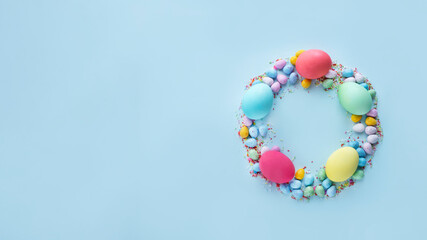 Fototapeta na wymiar Easter wreath made of dyed eggs and candies. Web banner image with copy space