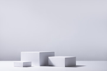Elegant abstract set of white podiums in sunlight with shadow on white background for product display. Simple modern geometric design.