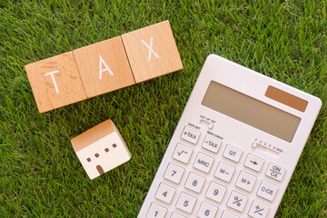 税金｜「TAX」と書かれた積み木と電卓と小銭