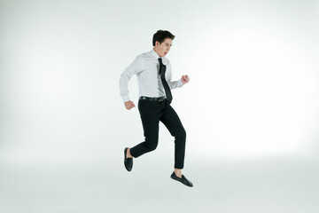 Portrait of self-confidence young and handsome Asian businessman executive looked in shirt and tie jumping high and freeze stop in air, copy space studio shot isolated on white background