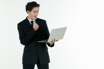 Portrait of self confidence young and handsome business Asian man in black suit holding notebook laptop computer with copy space studio shot isolated on white background