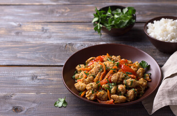Vegan stew soy meat and vegetables served with boiled rice and herbs on a wooden table. delicious healthy diet food. space, selective focus, horizontal	