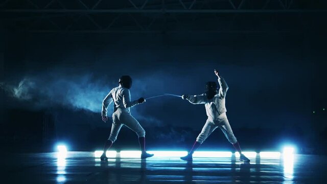 Slow motion of two competitors having a fencing training