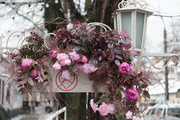 City street is decorated with artificial flowers.
