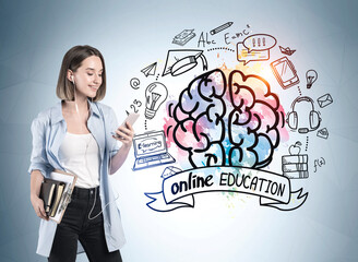 Attractive student woman in casual wear holding a notebooks, notepads and smartphone and listening to music using headphones. Colorful distance learning education sketch on wall behind