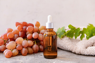 Bottle of grape seed oil on grey background