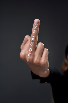 Hand showing middle finger with sales off inscription