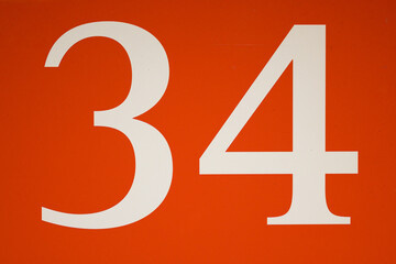 Colorful red and white sign with the number .thirty-four - 34