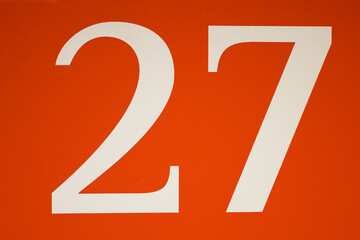 Colorful red and white sign with the number twenty-seven - 27