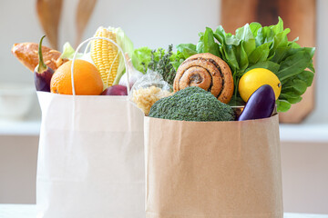 Paper bags with different products on table in kitchen