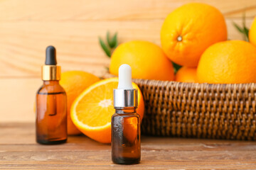 Bottles of orange essential oil on wooden background