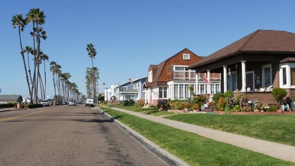 Houses on suburban street in California USA, Oceanside. Generic buildings in residential district near Los Angeles. Real estate property exterior. Tropical gardens, palms near typical american homes.