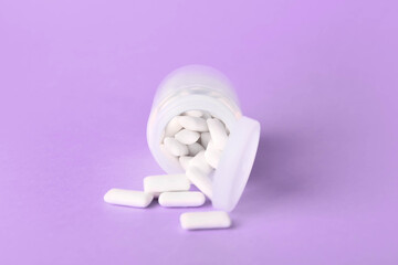 Jar with tasty chewing gums on color background