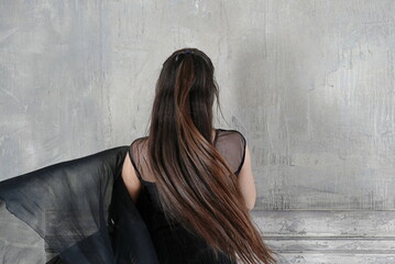 Woman dancer backside in motion with a cloth against the wall