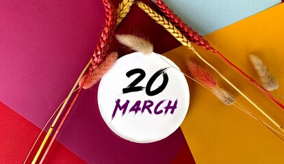 March 20 on a white round object.Near the sprigs of wheat on a colorful bright background.Calendar for March .